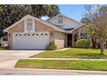Charming single-Gathering home with brick facade, attached two-car garage and well-manicured lawn at 914 Smokerise Blvd, Port Orange, FL 32127