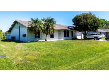 Charming single-story home with a spacious front yard and mature palm trees, perfect for curb appeal at 950 Windway Cir, Kissimmee, FL 34744