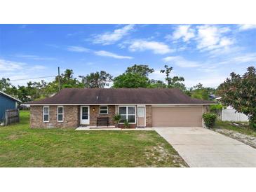 Charming single-story brick home featuring a well-maintained lawn and attached two-car garage at 1054 Abeline Dr, Deltona, FL 32725