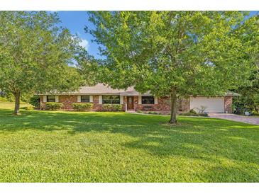 Charming brick home featuring a well-manicured lawn and mature trees at 349 Evansdale Rd, Lake Mary, FL 32746