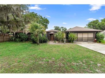 Charming single Gathering home with a well-manicured lawn and mature trees at 411 Columbus Ave, Orange City, FL 32763