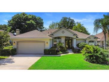 Well-maintained single-story home with a two-car garage, manicured lawn, and lush landscaping at 508 Quail Lake Dr, Debary, FL 32713