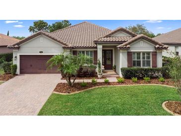 Charming single-story home featuring a well-manicured lawn, mature palm tree, and brick-paved driveway at 716 Riviera Bella Dr, Debary, FL 32713