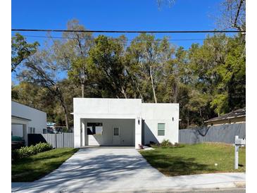 Modern home featuring a minimalist design, covered parking and landscaped yard at 736 S Stone St, Deland, FL 32720