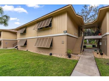 Condo exterior featuring shuttered windows and well-maintained landscaping, offering curb appeal and a welcoming facade at 140 Orchid Woods Ct # 14B, Deltona, FL 32725