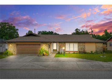 Charming single-story home featuring stone accents, a well-manicured lawn, and an attached two-car garage at 1426 Saxon Blvd, Deltona, FL 32725
