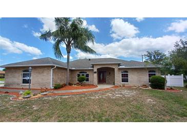 Charming brick home with a well-manicured front yard and inviting entryway at 1491 E Palomar Dr, Deltona, FL 32738