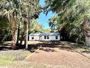 Charming single-story home featuring mature trees and a long driveway at 249 Citra St, De Leon Springs, FL 32130