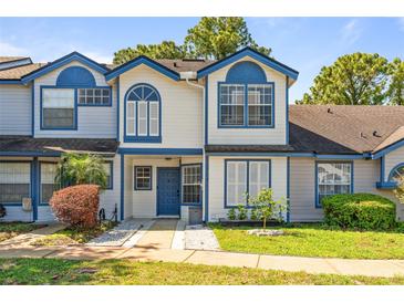 Inviting townhouse with blue trim, well-maintained landscaping, and a charming front entrance at 2704 Lancaster Ct, Apopka, FL 32703