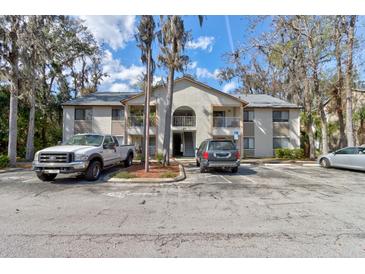 Condominium building featuring multiple units, mature landscaping, and ample parking on a sunny day at 2706 Oak Trail Run # 6, Port Orange, FL 32127