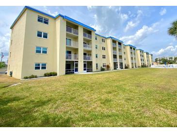 Spacious condominium with white balconies and a blue roof, surrounded by lush green grass at 3131 S Ridgewood Ave # 4120, Daytona Beach, FL 32119
