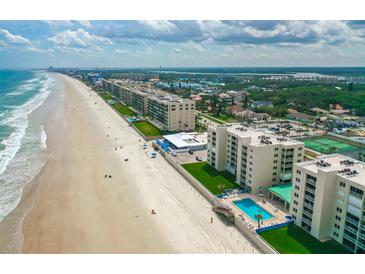 Breathtaking aerial view of beachside condos, sandy beach, and sparkling ocean at 4505 S Atlantic Ave # 505, Ponce Inlet, FL 32127