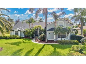 Beautiful single-Gathering home with lush landscaping and mature palm trees, creating a tropical feel at 483 N Pine Meadow Dr, Debary, FL 32713