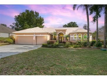 Charming single-story home with a well-manicured lawn, beautiful landscaping, and a two-car garage at 484 Lanarkshire Pl, Apopka, FL 32712