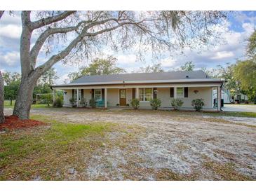 Inviting single-story home with a covered front porch and a well-maintained lawn at 5410 Deleon Springs Ranch Rd, De Leon Springs, FL 32130