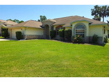 Charming single-story home with well-manicured lawn and lovely landscaping with a 2-car garage at 6182 Knotty Pine Ct, Port Orange, FL 32127