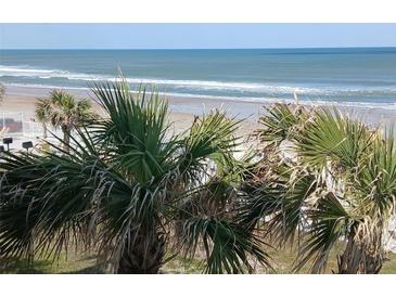 Breathtaking beach view framed by palm trees, showcasing the ocean and sandy shoreline at 935 S Atlantic Ave # 364, Daytona Beach, FL 32118