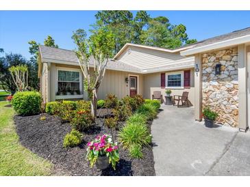 Beautiful home featuring a landscaped front yard with lovely plants and an inviting entrance way at 101 Sweetwater Oaks Ln, Daytona Beach, FL 32114