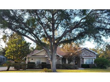 Charming single-story home with mature trees, stone accents, and a well-manicured lawn at 1072 Ceasars Ct, Mount Dora, FL 32757