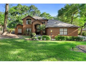 Charming two-story brick home with a well-manicured lawn and mature trees at 1081 Torchwood Dr, Deland, FL 32724