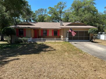 Charming single-story home featuring a well-maintained lawn, red shutters, and attached garage at 1179 Heidi Ct, Deland, FL 32720