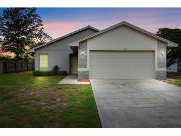 Charming single-story home features a two-car garage and well-maintained front lawn at 1222 Madelena Ave, Winter Springs, FL 32708