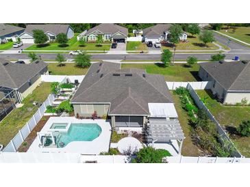 Aerial view of a home's backyard featuring a pool, landscaped garden, and outdoor living space at 1613 Lady Fern Trl, Deland, FL 32720