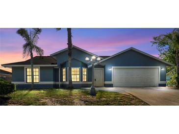 Charming blue single-story home with a two-car garage and manicured front lawn at 1842 W Cooper Dr, Deltona, FL 32725