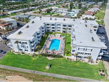 An aerial view shows the condo complex with a pool and surrounding palm trees at 1926 Ocean Shore Blvd # 3050, Ormond Beach, FL 32176