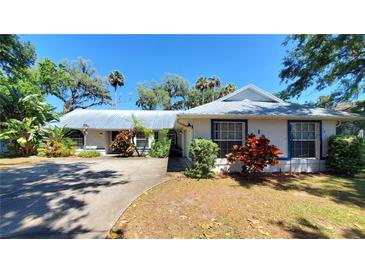 Charming single story home with a metal roof, mature landscaping, and a well maintained front yard at 1927 Orange Tree Dr, Edgewater, FL 32141