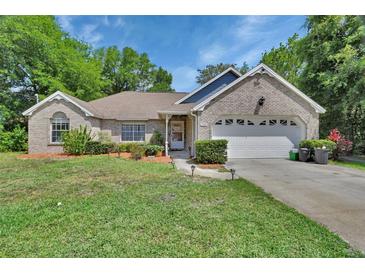 Charming single-story brick home featuring a well-manicured front lawn and attached two-car garage at 2355 W Orange Rd, Deland, FL 32724
