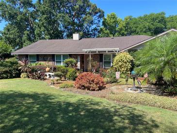 Charming brick home with a meticulously landscaped front yard, lush greenery, and welcoming facade at 2427 Beck Cir, Deltona, FL 32738