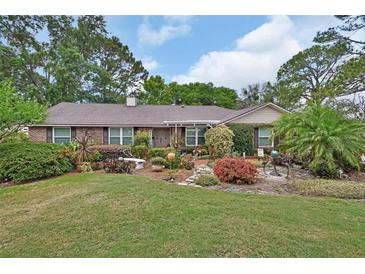 Charming single story brick home with a meticulously landscaped front yard and colorful foliage at 2427 Beck Cir, Deltona, FL 32738