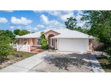 Charming single-story home with well-maintained landscaping, a brick walkway, and a two-car garage at 2466 Candlewick St, Deltona, FL 32738