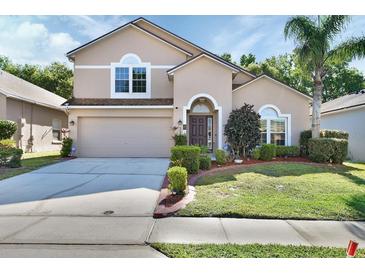 Charming two-story home with a well-manicured lawn, mature landscaping, and a two-car garage at 261 Clydesdale Cir, Sanford, FL 32773
