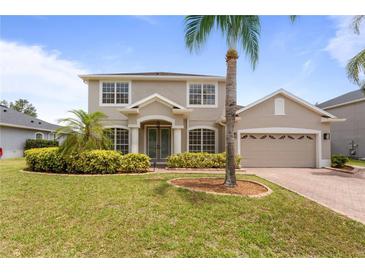 Charming two-story home featuring a well-manicured lawn, lush landscaping, and a two-car garage at 3333 Atmore Ter, Ocoee, FL 34761