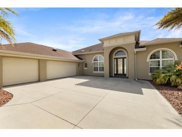 Stunning single-story home featuring a 3-car garage, arched windows, and a spacious concrete driveway at 3470 Tesoro Cir, New Smyrna Beach, FL 32168