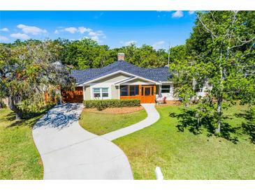 Charming home featuring a curved walkway, mature trees, and a cozy screened front porch entrance at 426 N Boyd St, Winter Garden, FL 34787