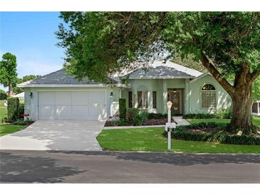 Charming single-story home with a well-manicured lawn, mature trees, and a two-car garage at 5097 Nw 19Th Pl, Ocala, FL 34482