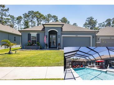 Beautiful single-Gathering home features a two-car garage, lawn, flowerbeds, and a screened-in pool at 6006 Mount Zion Cir, Deland, FL 32724