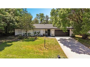 Charming single-story home featuring a lush front yard, brick accents, and attached two-car garage at 639 Elwood St, Deltona, FL 32725