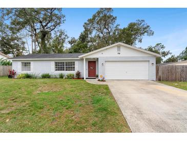 Charming single-story home showcasing well-maintained landscaping and a classic red door at 732 Mockingbird Ln, Deland, FL 32720