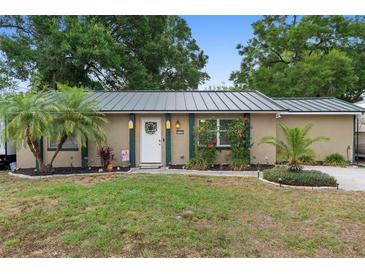 Charming home with a well-manicured lawn, palm tree, and decorative accents by the front door at 1135 5Th St, Orange City, FL 32763