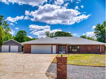 Charming single-story brick home with a long driveway and detached two-car garage at 1371 Merrifield Ct, Deltona, FL 32725