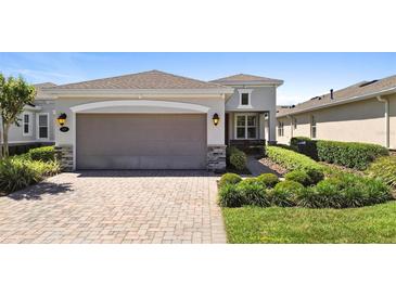 Charming single Gathering home featuring a two car garage, neutral paint, manicured lawn, and lovely landscaping at 1374 Red Clover Ln, Deland, FL 32724