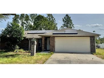 Charming single-story brick home featuring a two-car garage and solar panels at 1649 Courtland Blvd, Deltona, FL 32738