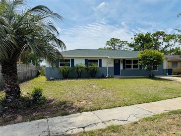 Charming single-story home with a well-maintained lawn, blue shutters, and a beautiful palm tree in the front yard at 1808 Green Pl, Ormond Beach, FL 32174