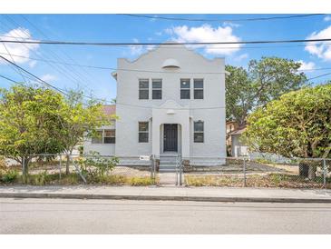 Bright two-story stucco home featuring a gated front yard and a sturdy, classic architectural design at 216 Earl St, Daytona Beach, FL 32118