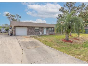 Charming single-story brick home with a well-manicured lawn and a concrete driveway at 2333 Fern Palm Dr, Edgewater, FL 32141