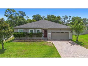 Charming single-story home featuring a brick driveway, well-maintained lawn, and a welcoming front entrance at 2337 Oxmoor Dr, Deland, FL 32724